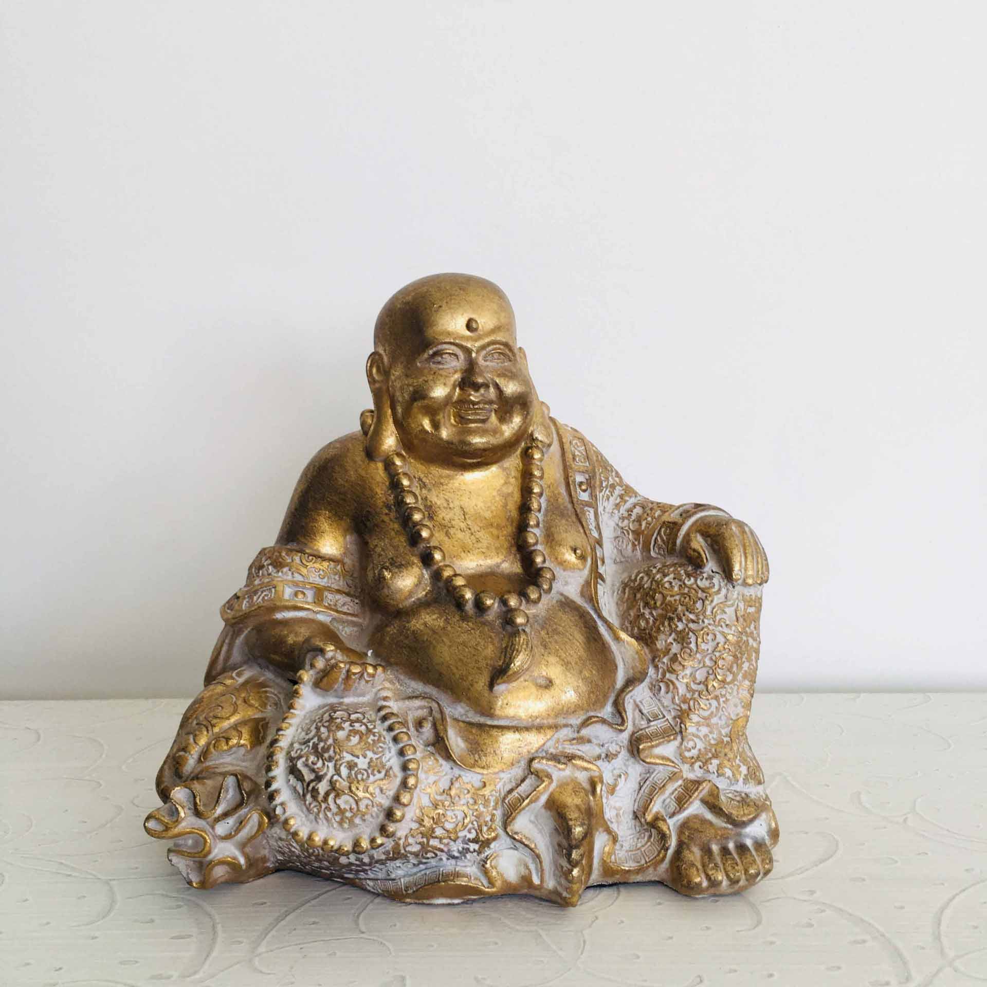 Estatueta dourada de Buda sentado com contas e roupas detalhadas