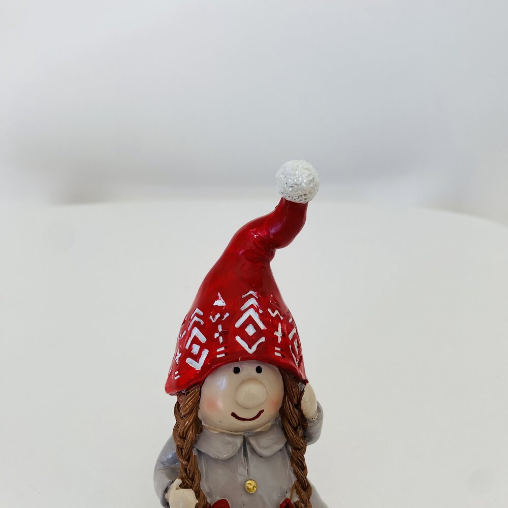 Figura decorativa de duende com gorro vermelho e padrão branco