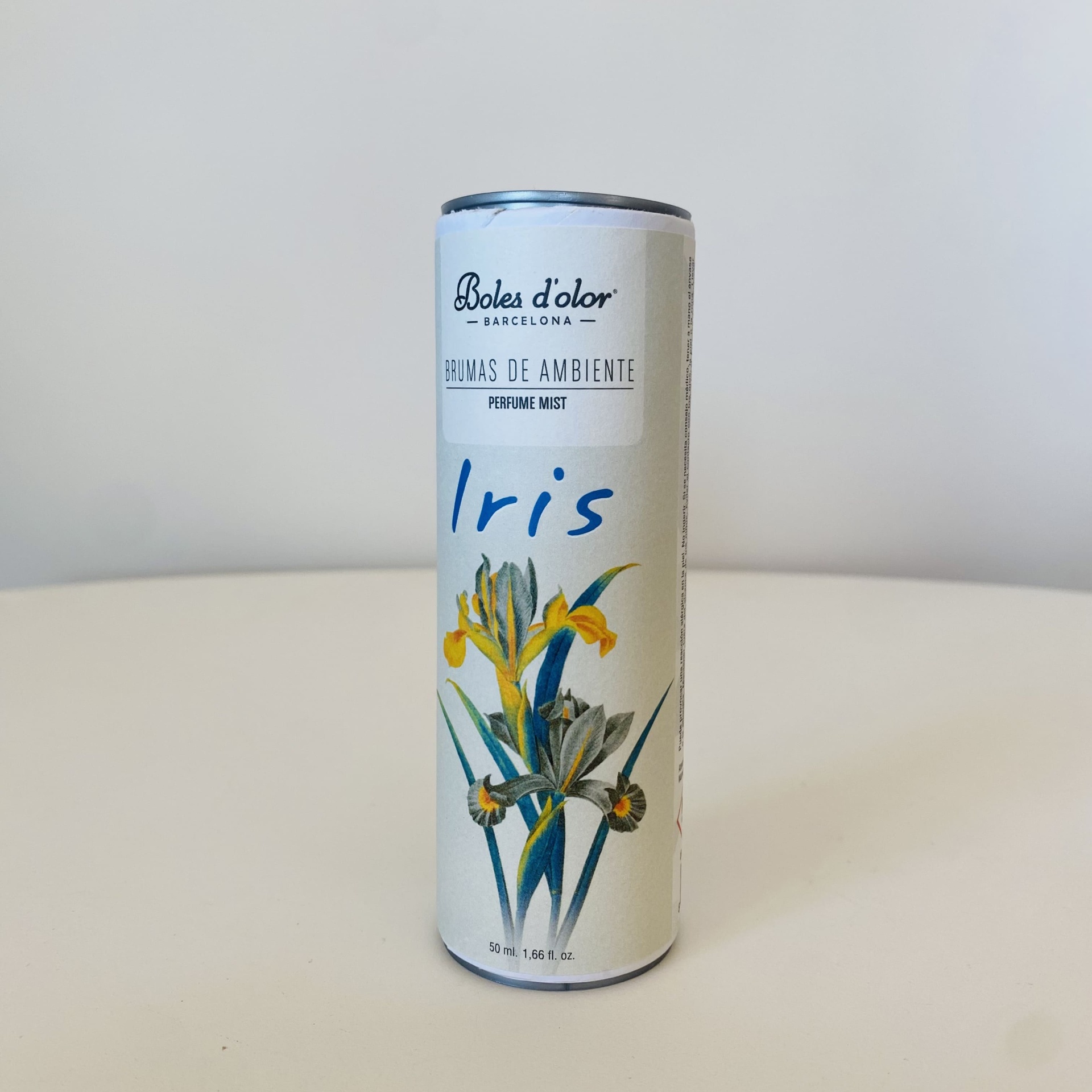 Frasco de perfume ambiente Boles d'olor Iris com ilustração floral e texto em branco.