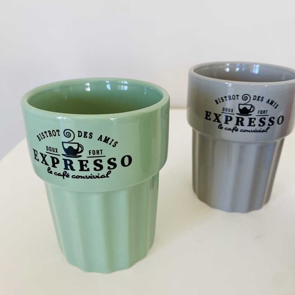 Duas canecas cerâmicas verde e cinzenta com texto preto e desenho de chávena de café