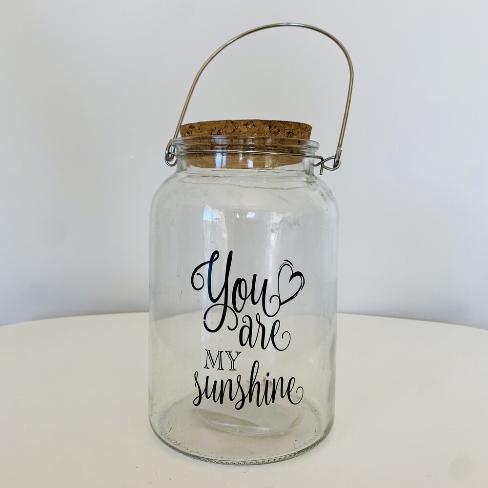 Frasco transparente com tampa de cortiça e texto decorativo