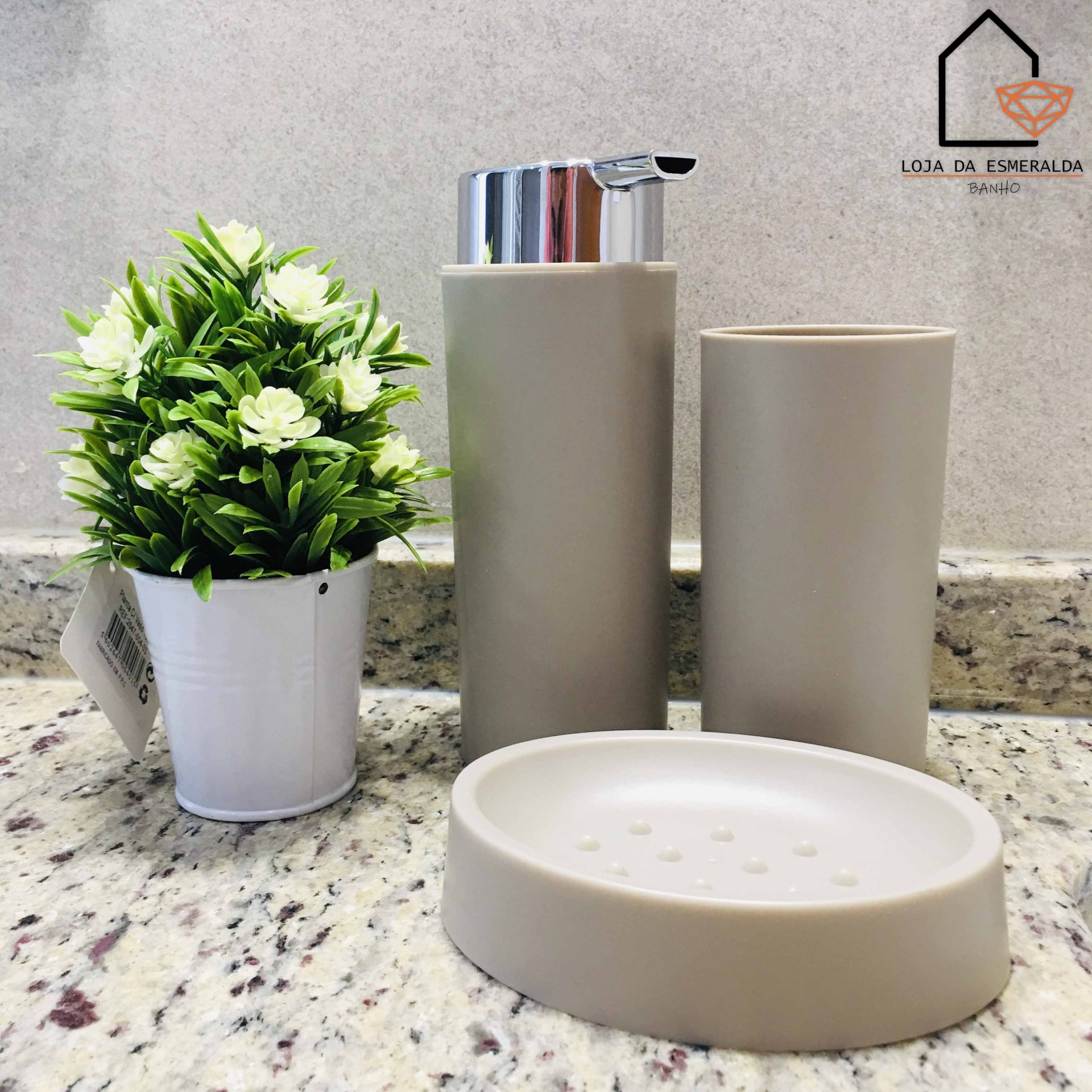 Conjunto de acessórios de casa de banho bege com planta artificial em vaso branco em bancada de mármore cinza