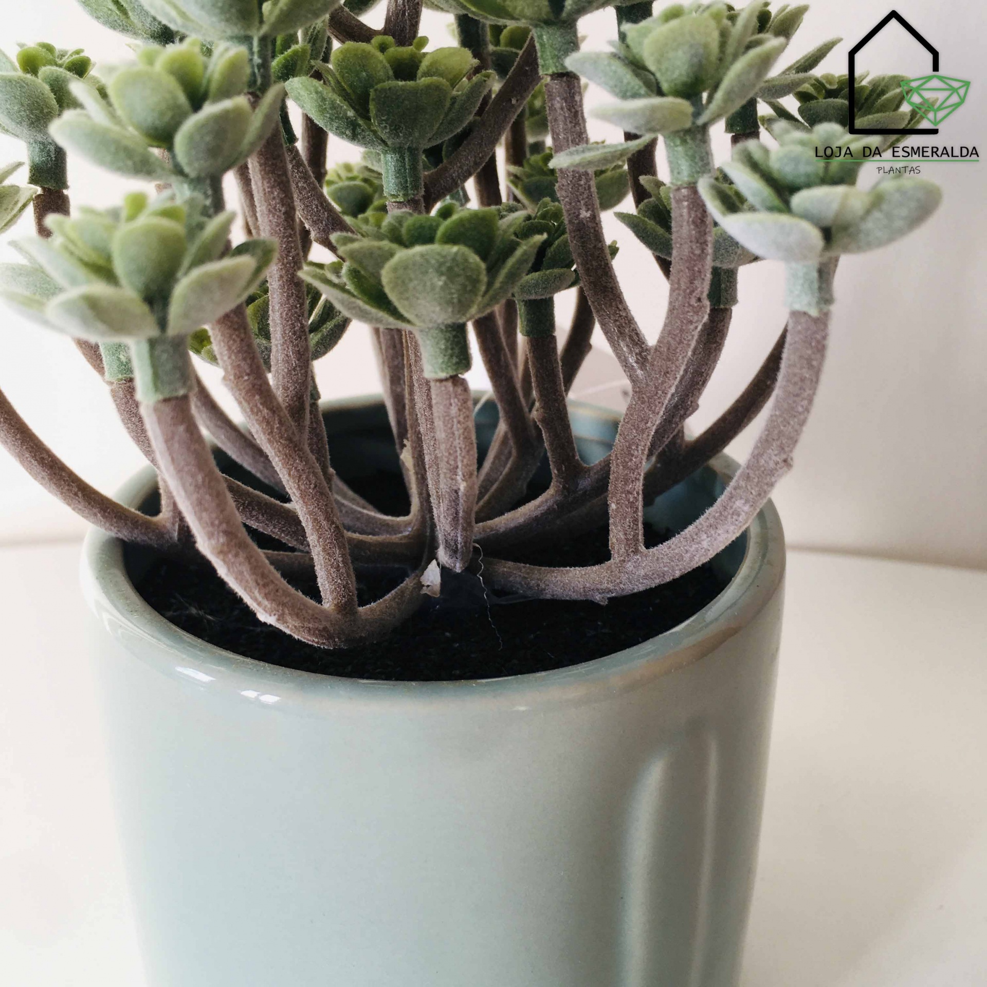 Vaso cinza claro com planta suculenta artificial e logo Loja da Esmeralda