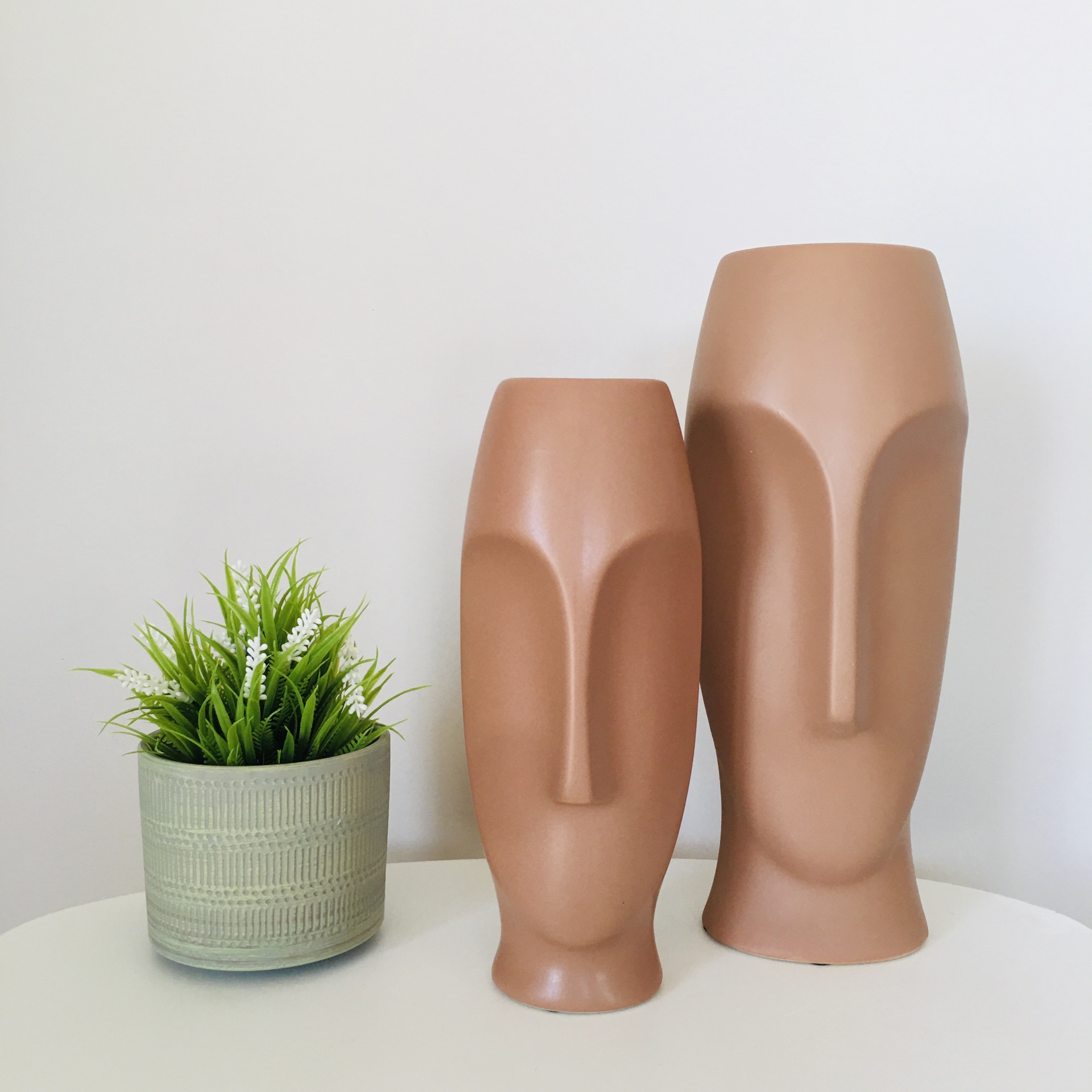 Esculturas decorativas rosto em terracota e vaso com planta