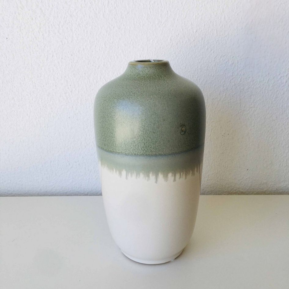 Vaso de cerâmica verde e branco sobre superfície branca