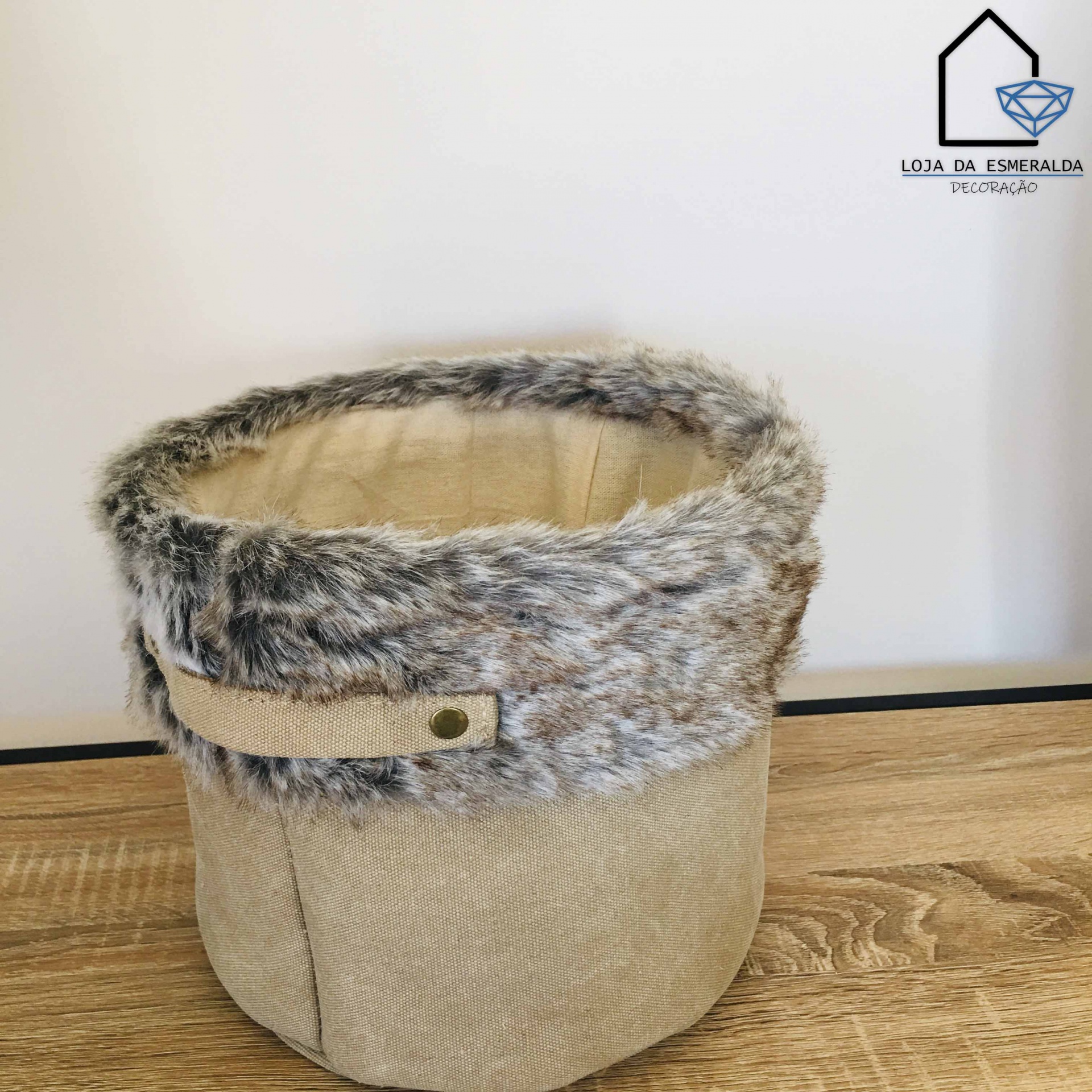 Cesto tecido bege com pelo sintético cinzento em superfície de madeira