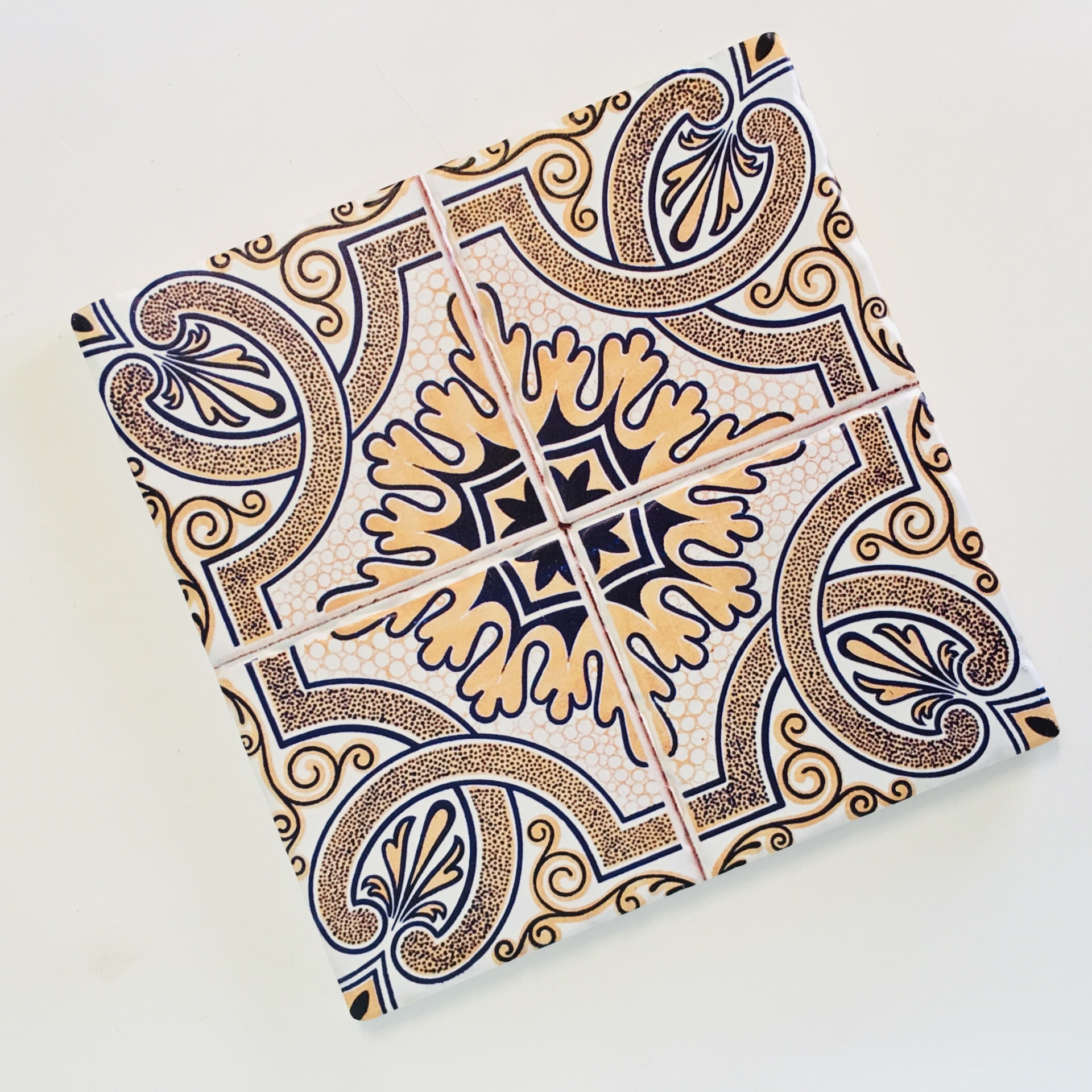 Azulejos quadrados com padrão decorativo em bege, preto e branco