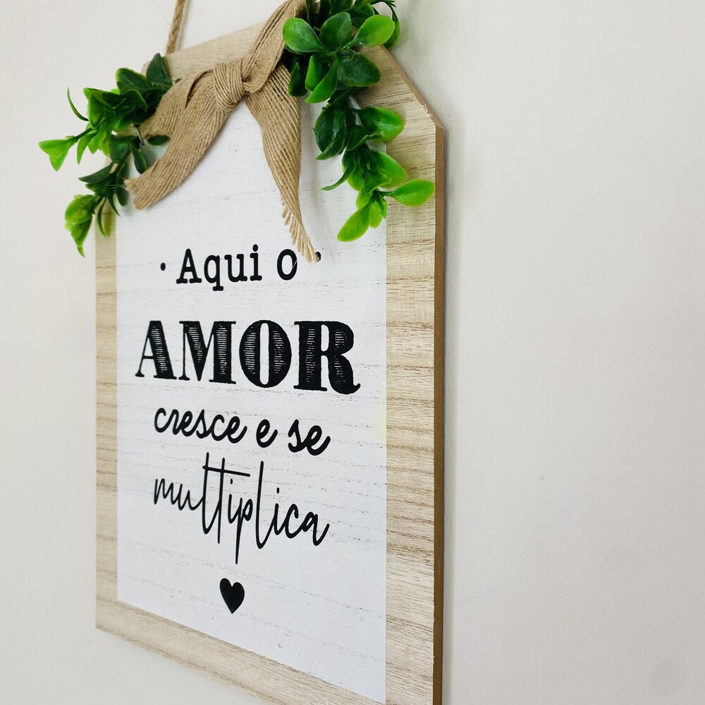 Placa decorativa de madeira com texto e folhagem verde