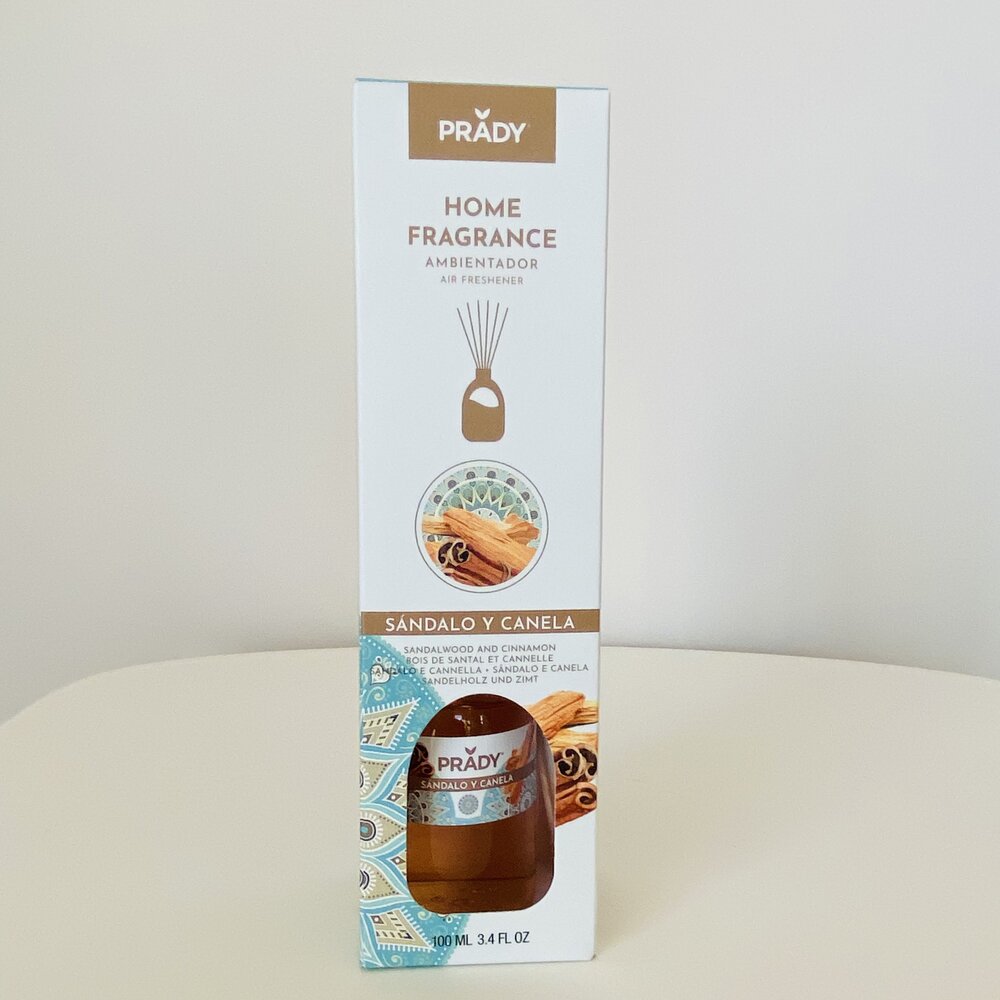 Embalagem branca de ambientador líquido Prady com imagens de canela e sândalo