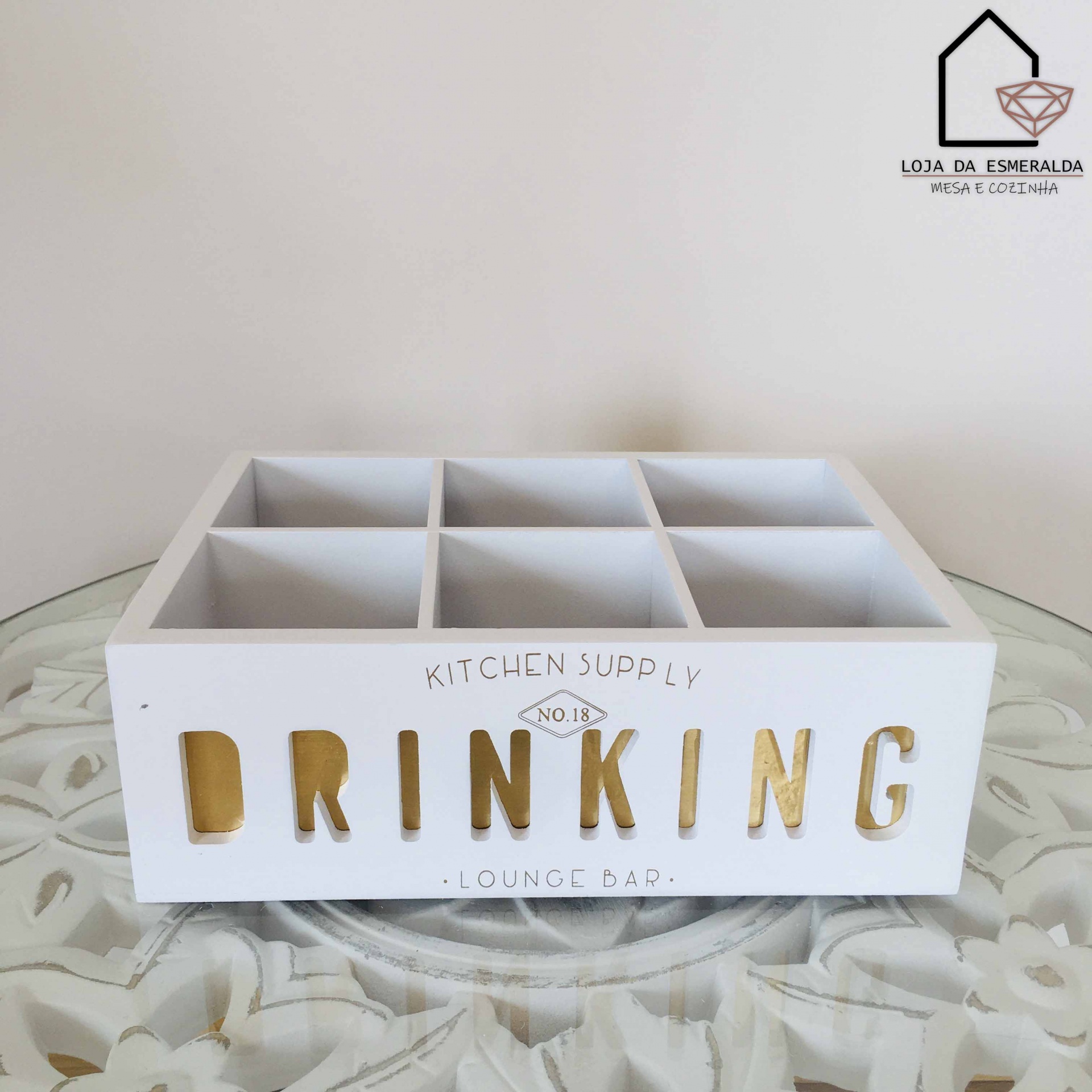 Caixa organizadora branca em madeira com texto decorativo e divisórias sobre mesa de vidro