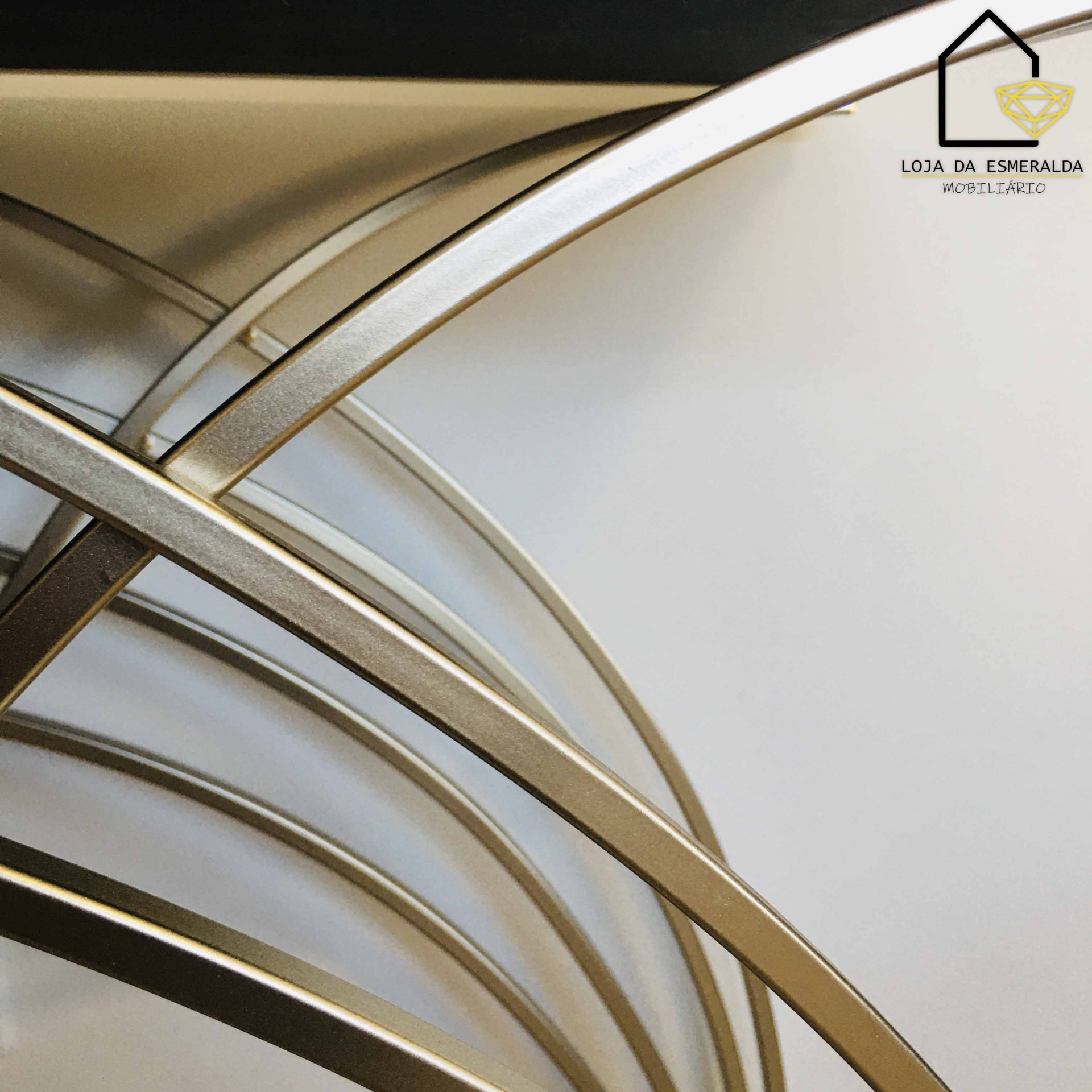 Estrutura metálica dourada curvada com logótipo Loja da Esmeralda