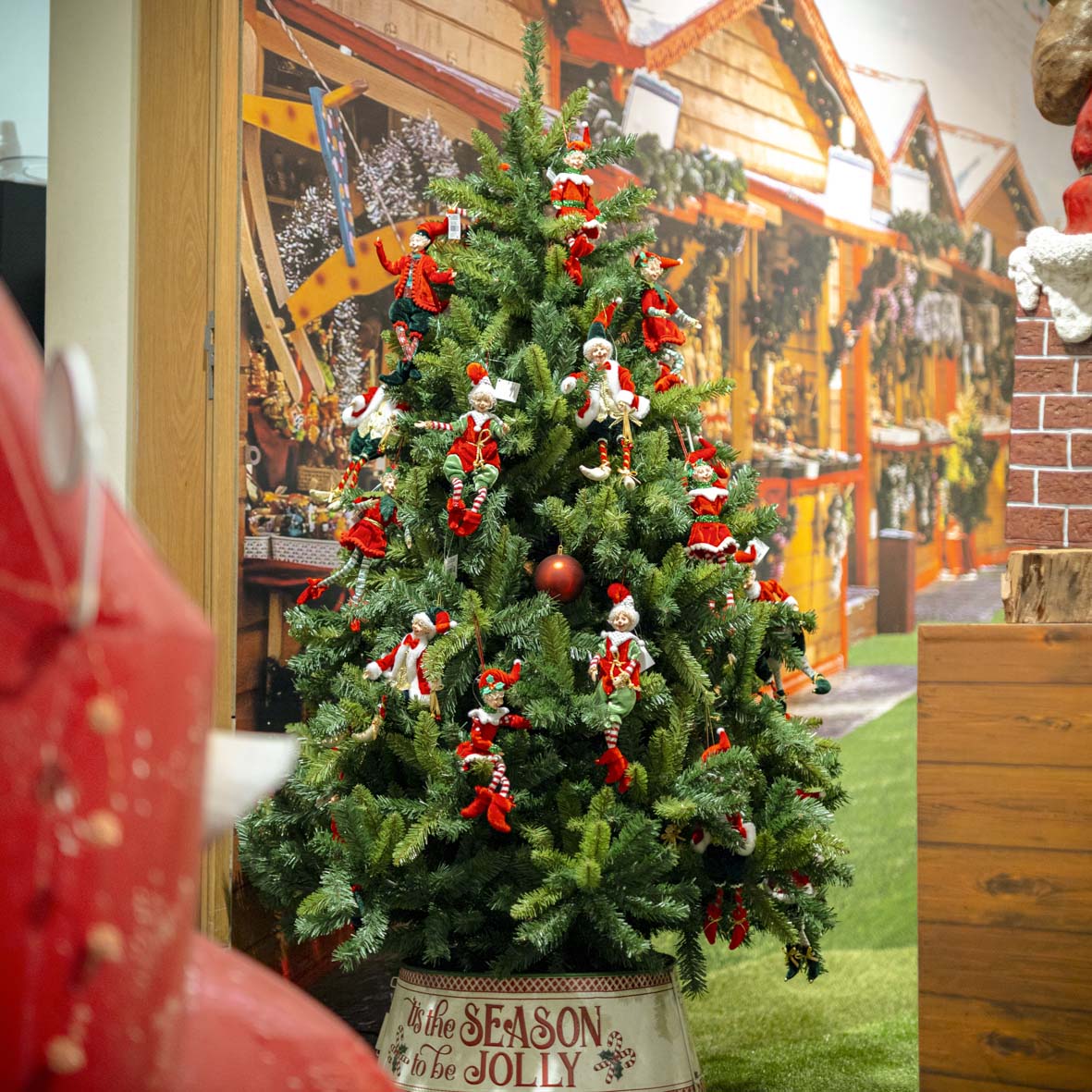 Árvore de Natal com elfos vermelhos e balde decorativo