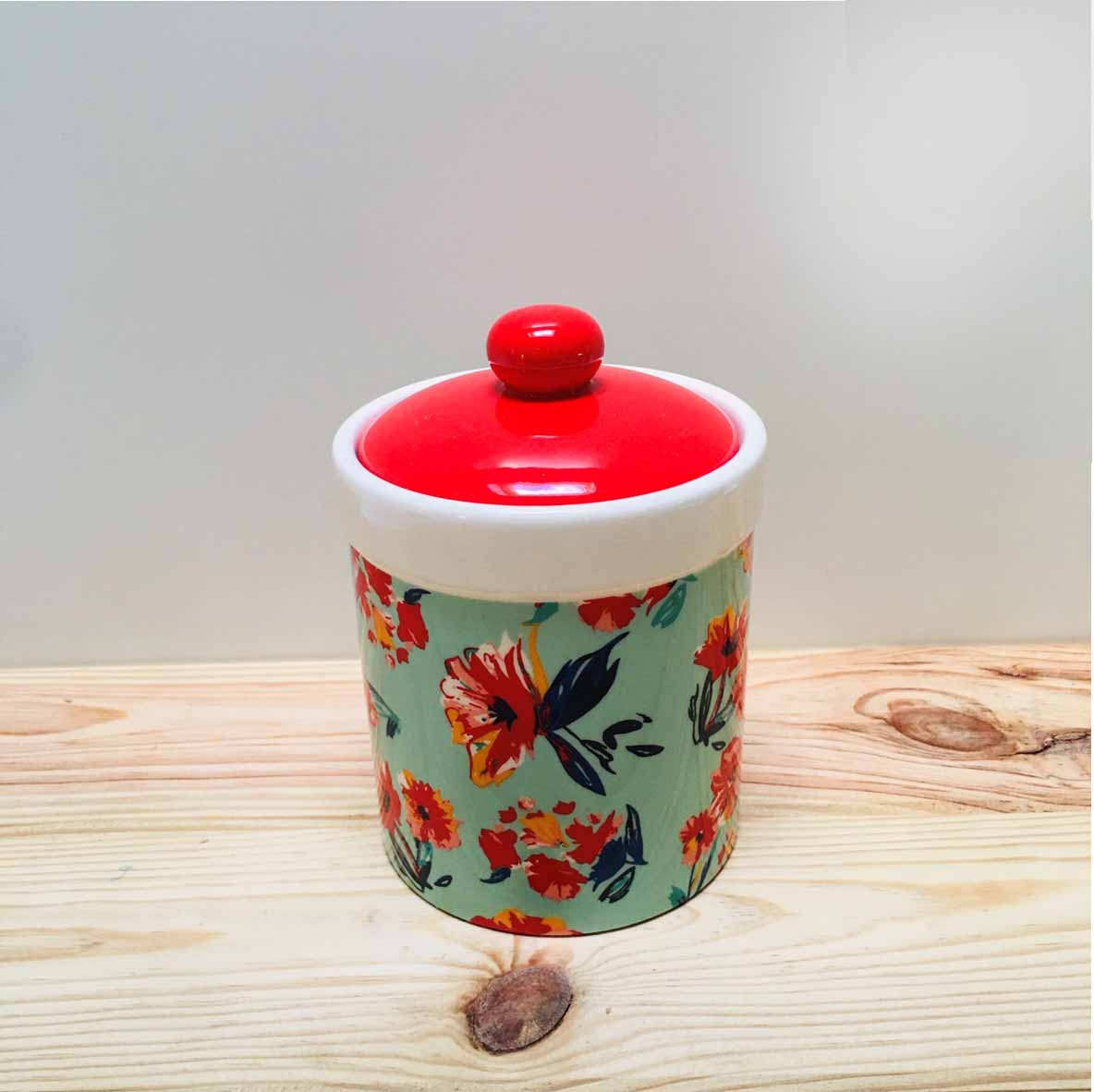 Frasco cilíndrico em cerâmica com tampa vermelha e corpo floral