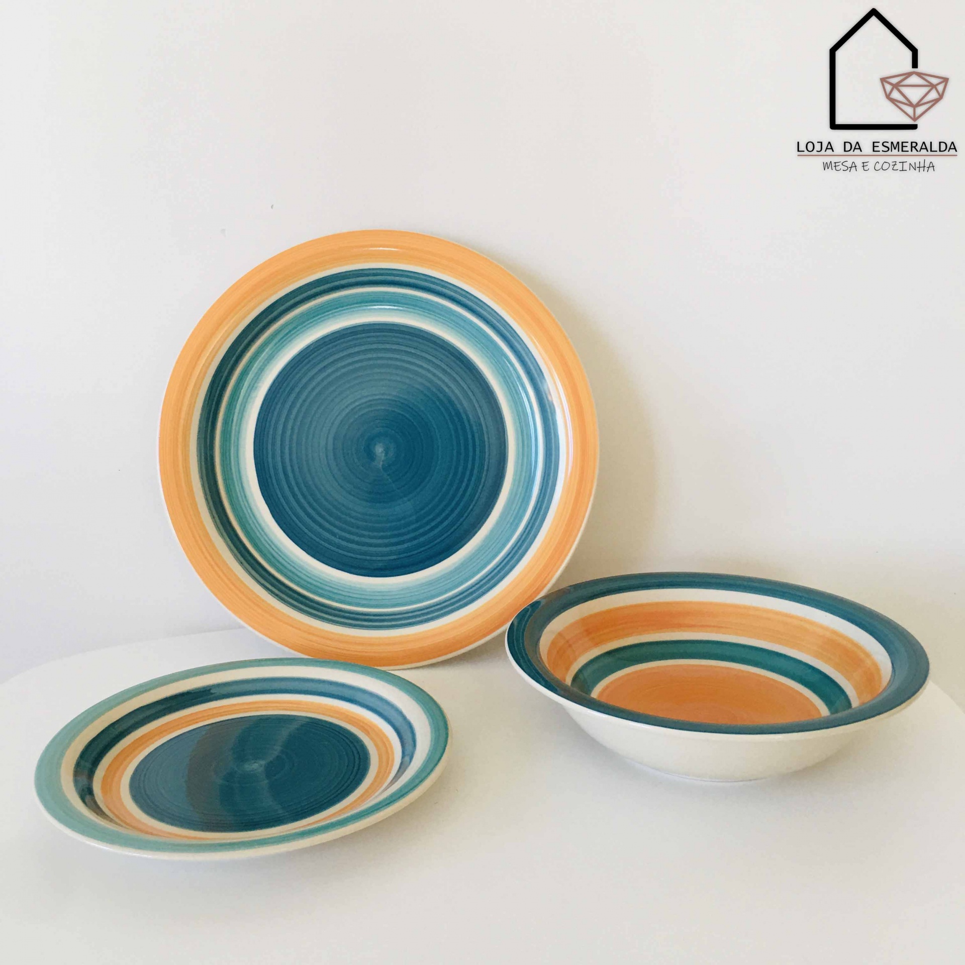 Conjunto de pratos em cerâmica com padrões coloridos e logótipo da loja