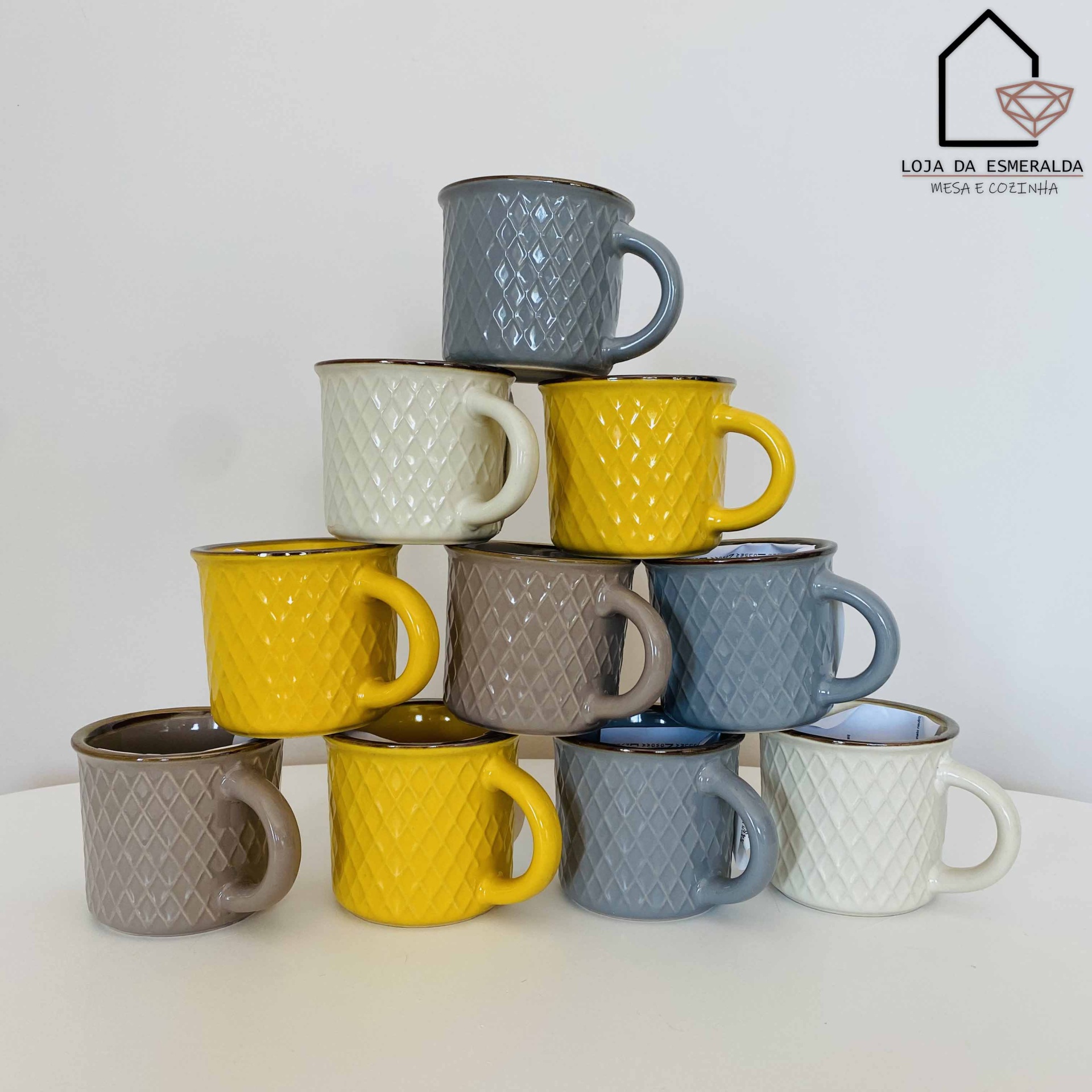 Conjunto de canecas cerâmicas coloridas empilhadas em pirâmide com textura geométrica