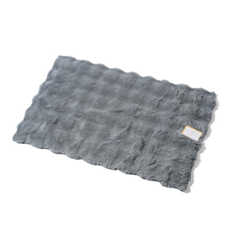 Tapete cinzento de pelúcia com textura ondulada e etiqueta