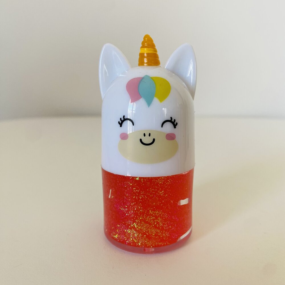 Figura de unicórnio pequeno branco com corpo vermelho e glitter, chifre amarelo e detalhes coloridos.