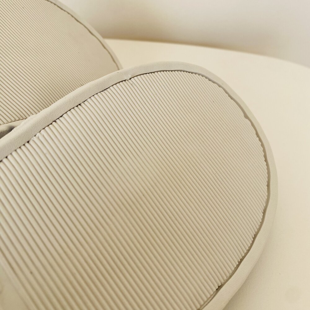 Palmilhas bege com textura de riscas sobre superfície clara