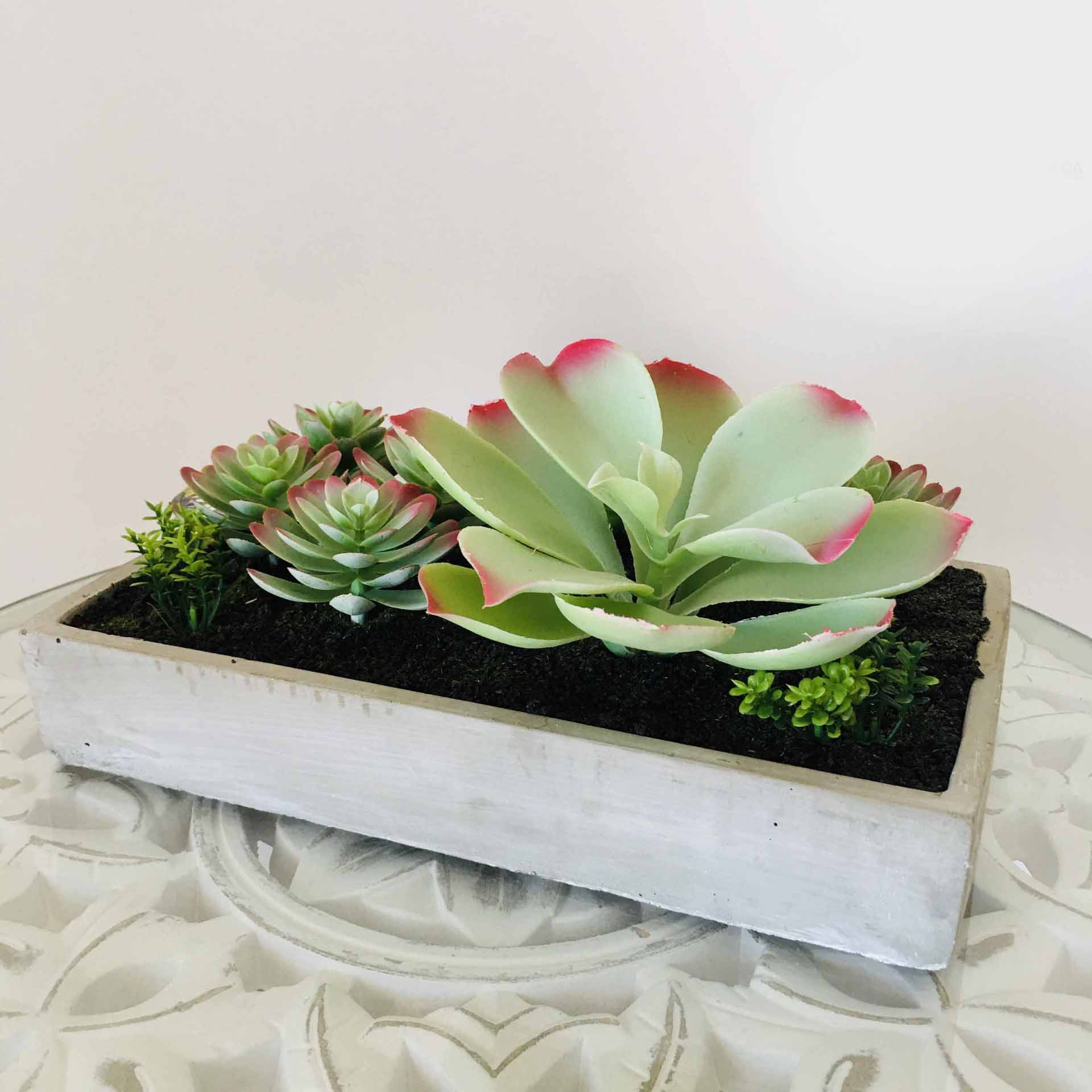 Plantas suculentas artificiais em vaso retangular de madeira branca