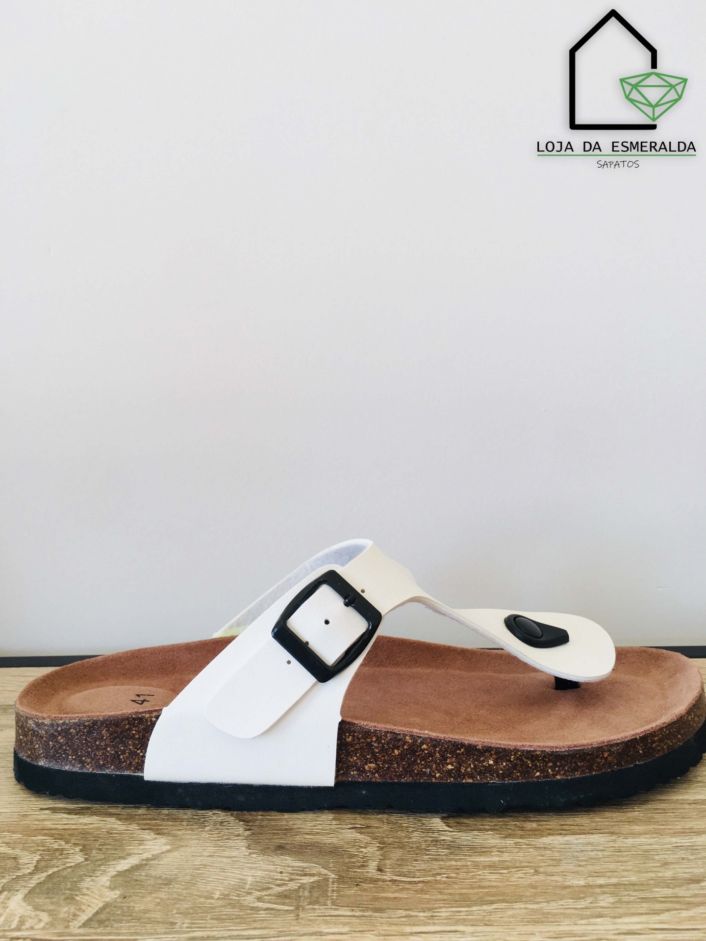 Sandália tipo chinelo branco com sola castanha em cortiça e fivela preta em fundo branco