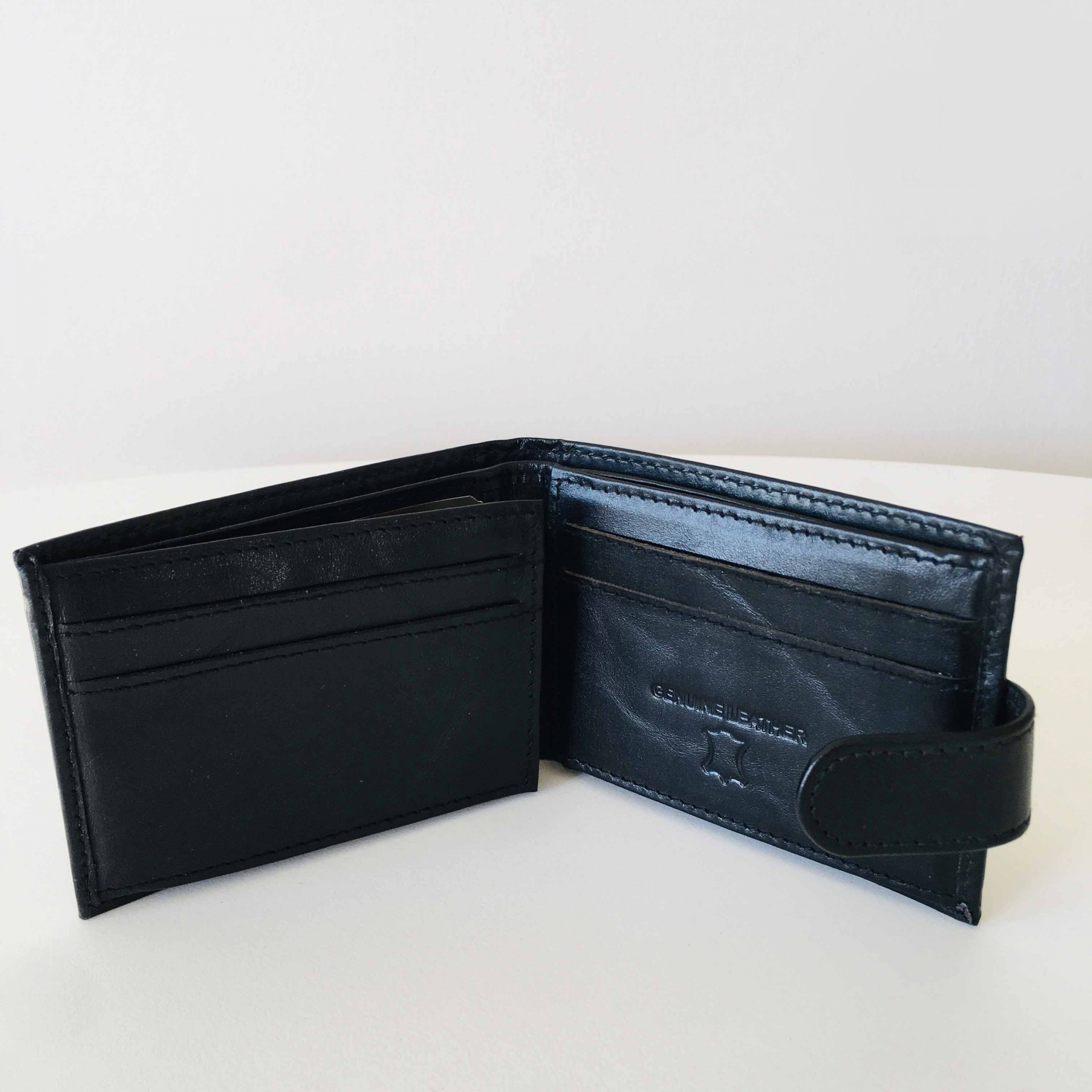 Carteira masculina preta aberta em pele sintética com compartimentos para cartões.