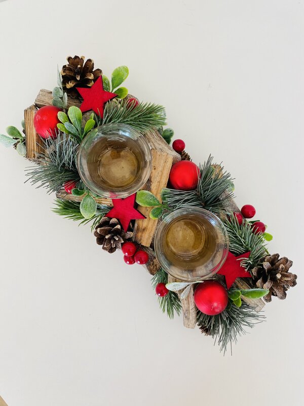 Arranjo natalício com pinhas, estrelas e suportes de vidro para velas