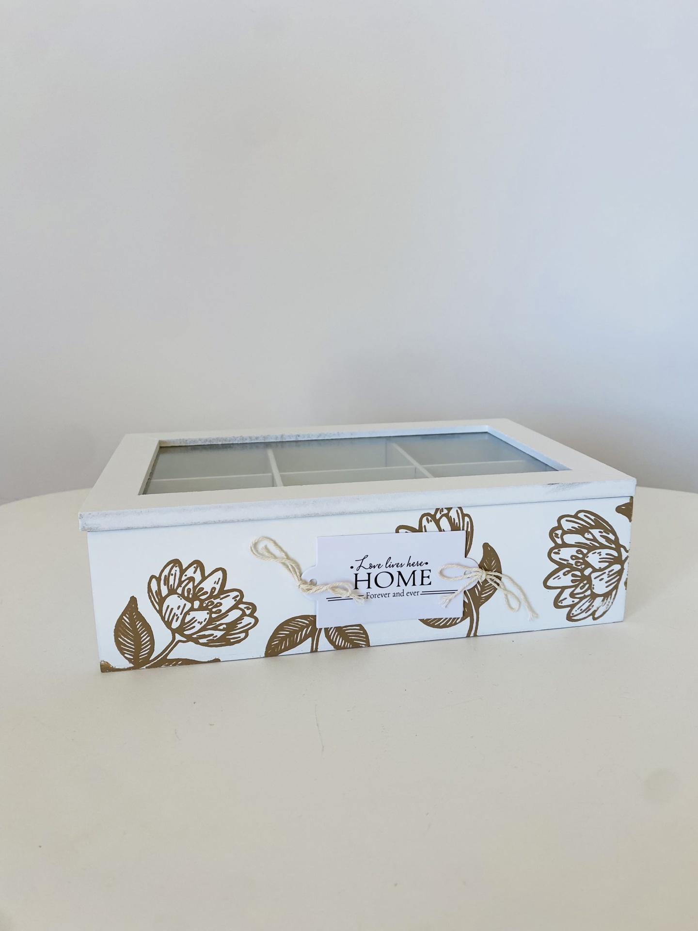 Caixa organizadora branca com tampa de vidro e decoração floral castanha