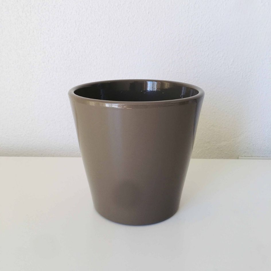 Vaso de cerâmica castanho escuro brilhante em superfície branca