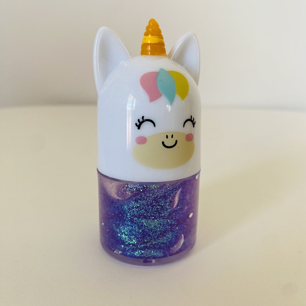 Frasco roxo com brilho e tampa em forma de unicórnio branco com chifre amarelo