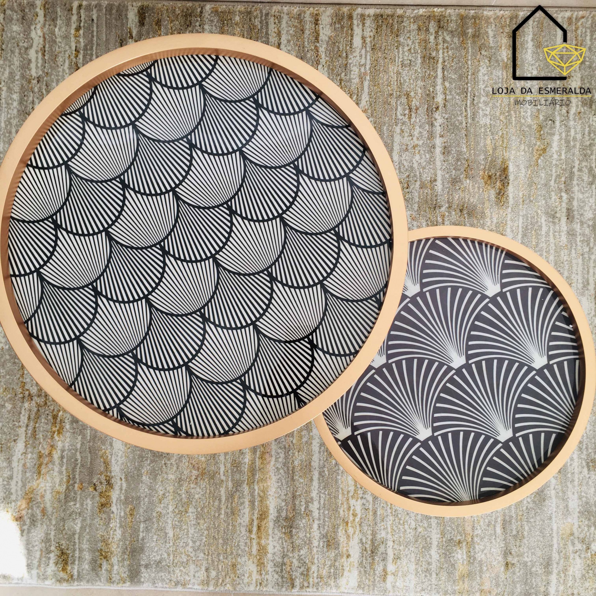 Dois tabuleiros redondos de madeira com padrões geométricos em preto e branco sobre tapete bege