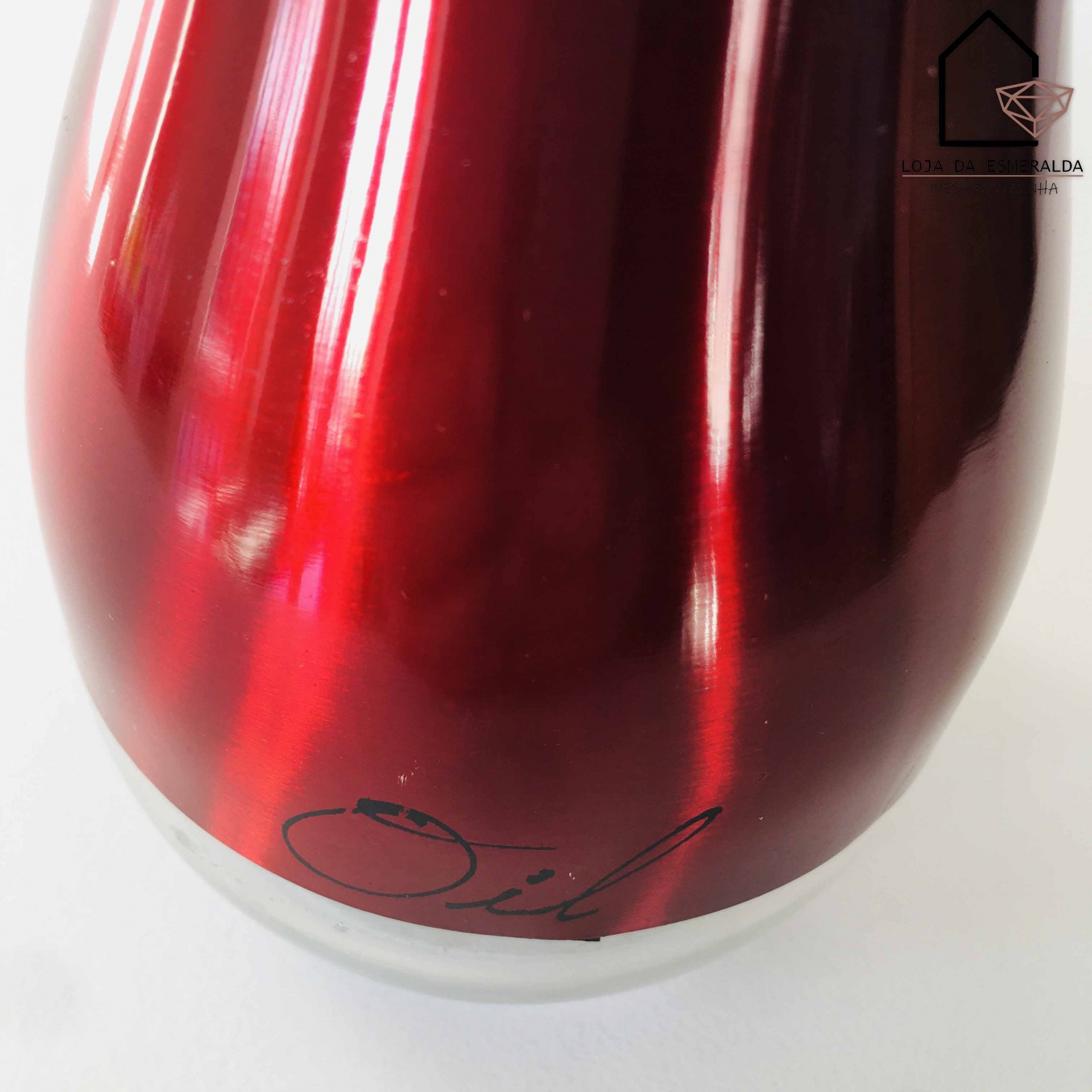 Frasco de vidro vermelho brilhante com texto Oil e base transparente