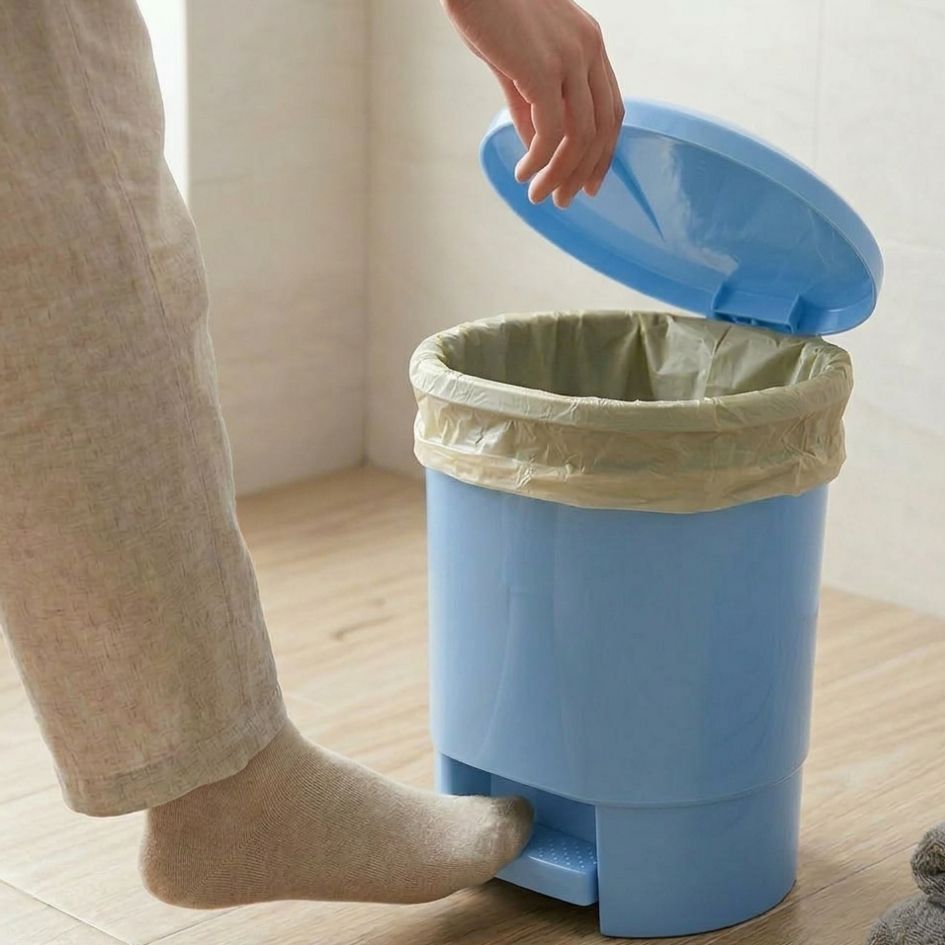 Contentor de lixo azul com pedal numa divisão com piso em madeira