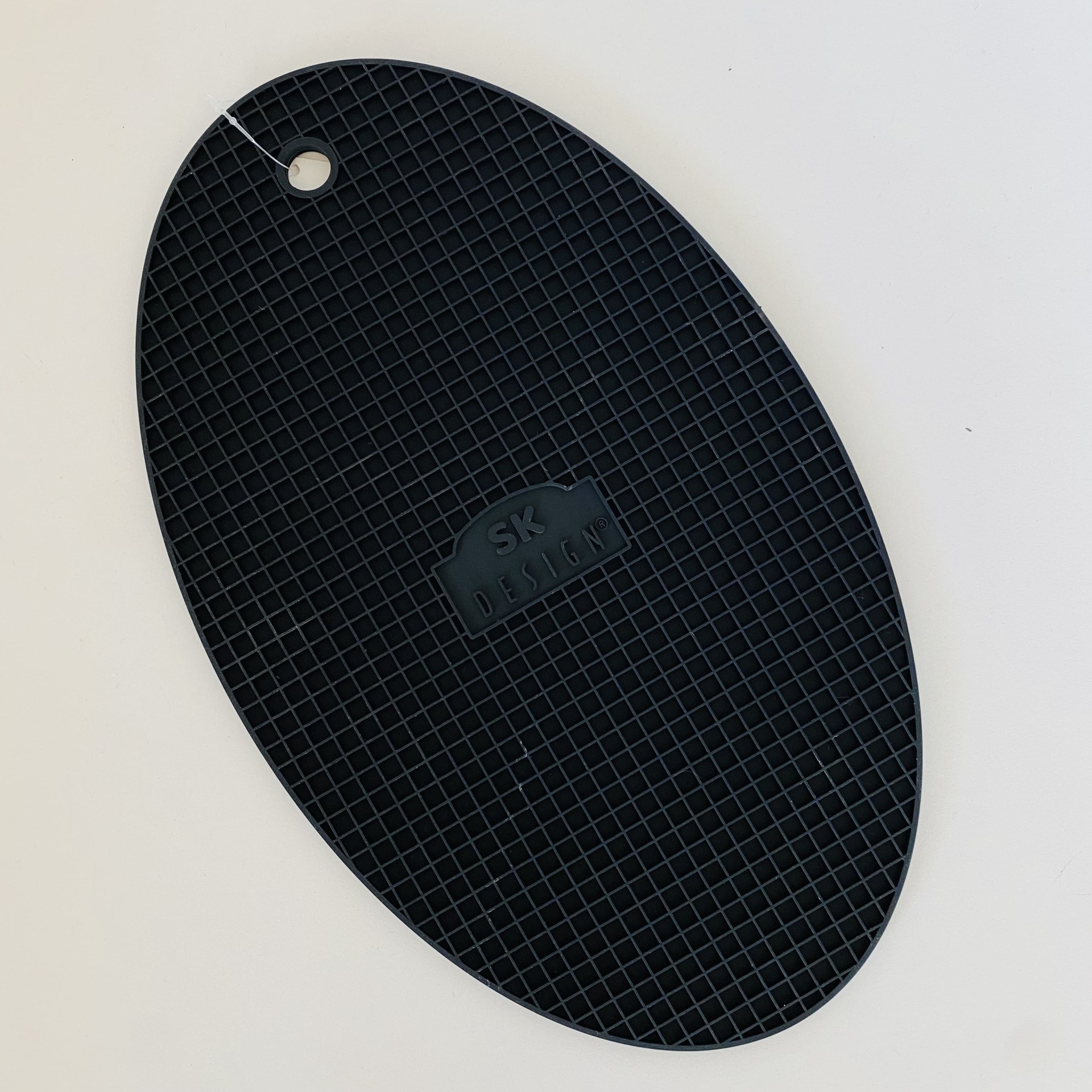 Base de silicone preta oval com textura de grelha e inscrição CENTRAL SKIN