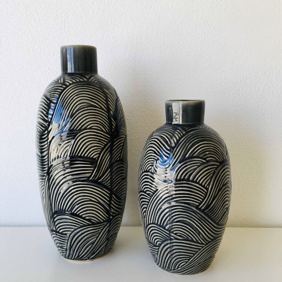 Duas jarras cerâmicas decorativas com padrão de linhas curvas preto e branco.