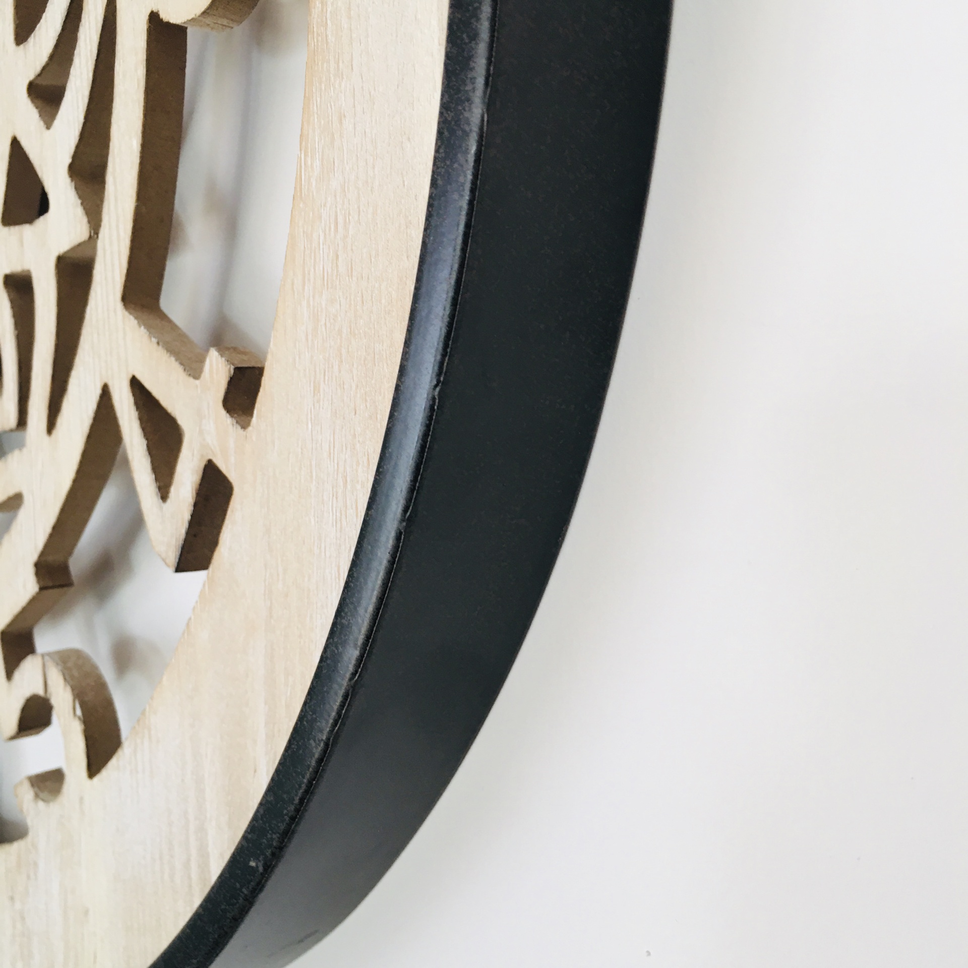 Relógio de parede com moldura preta e padrão geométrico em madeira clara