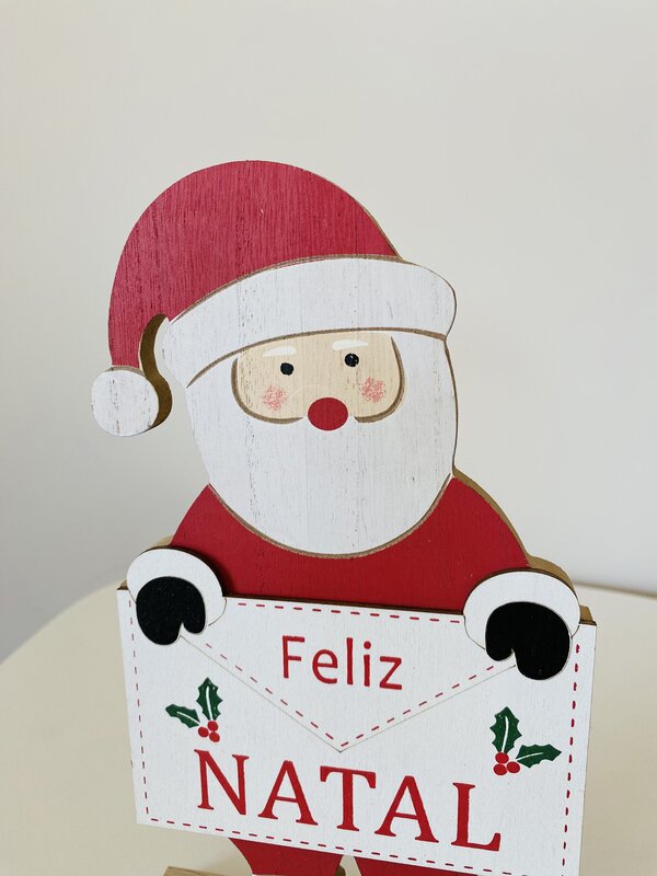 Decoração de Natal em forma de Pai Natal de madeira a segurar placa com texto Feliz Natal
