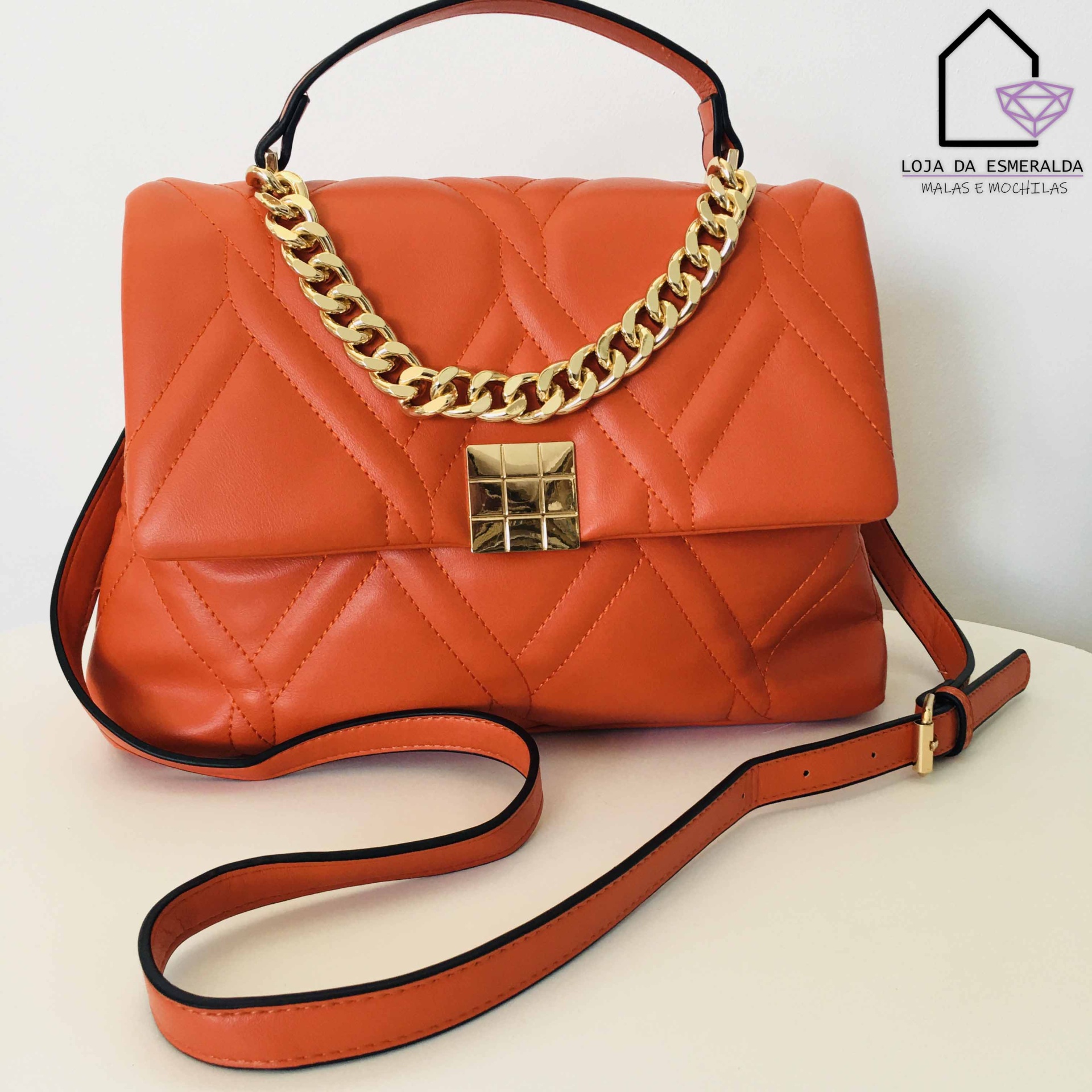 Mala de senhora laranja com corrente dourada e padrão de quilting
