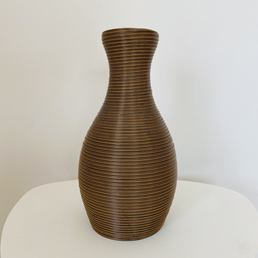 Vaso de vime castanho sobre superfície branca