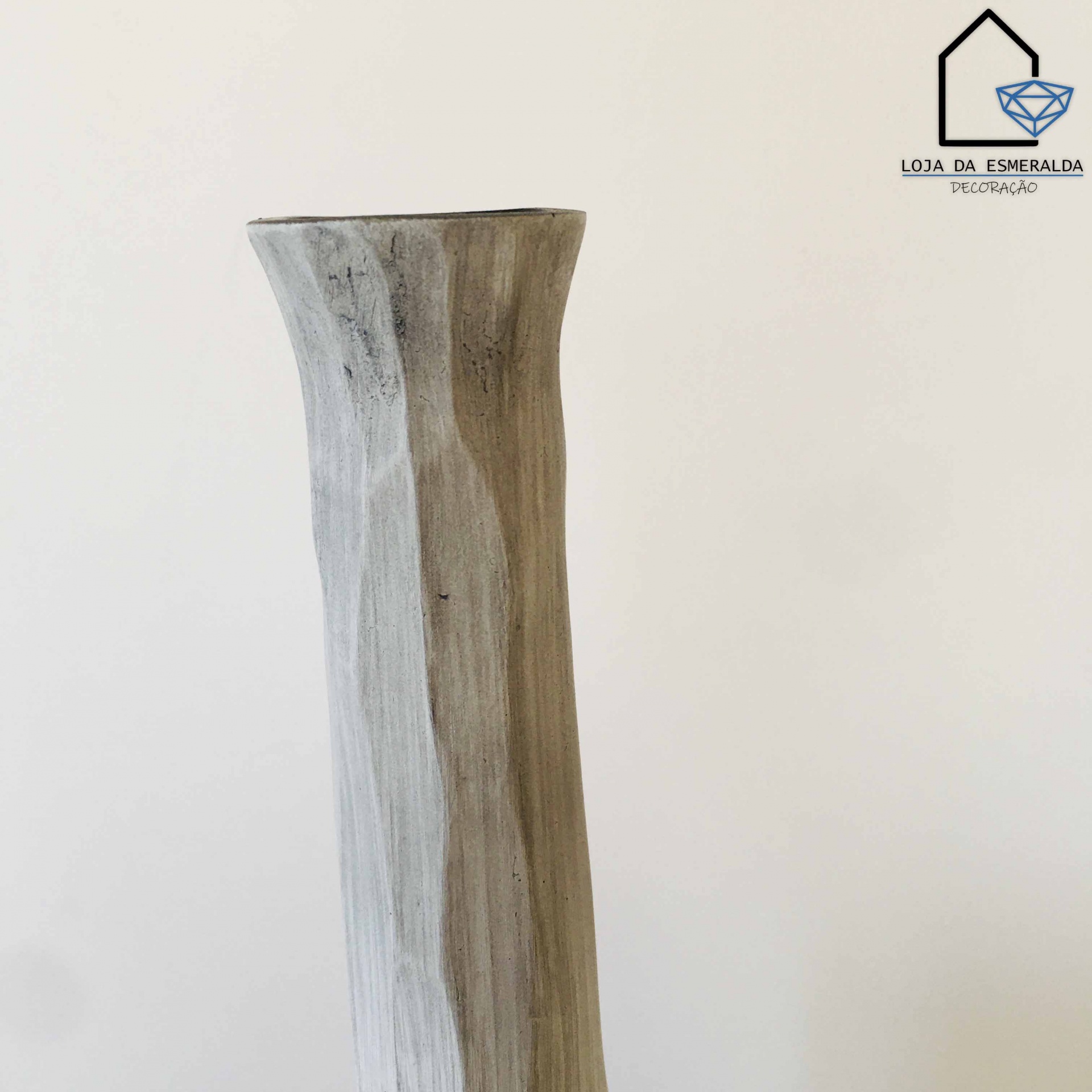 Vaso alto de cerâmica cinza com acabamento rústico e formato ondulado, em fundo branco com logótipo no canto