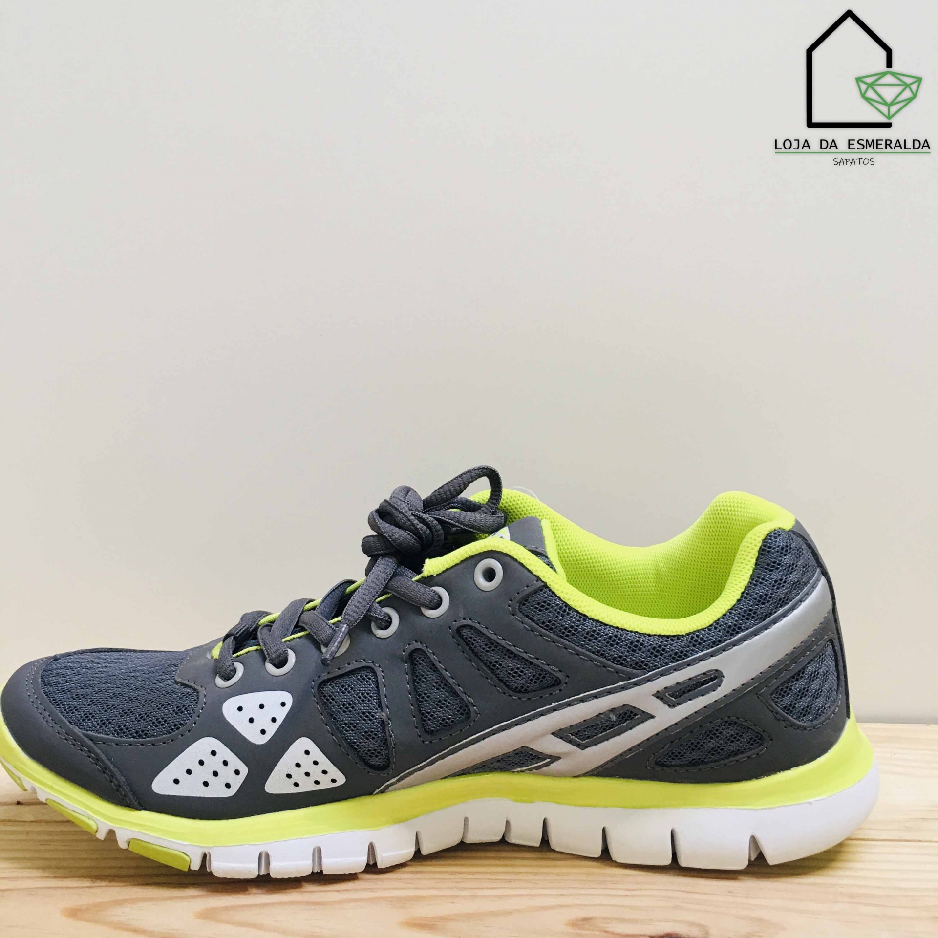 Tênis desportivo cinzento com detalhes amarelos e brancos