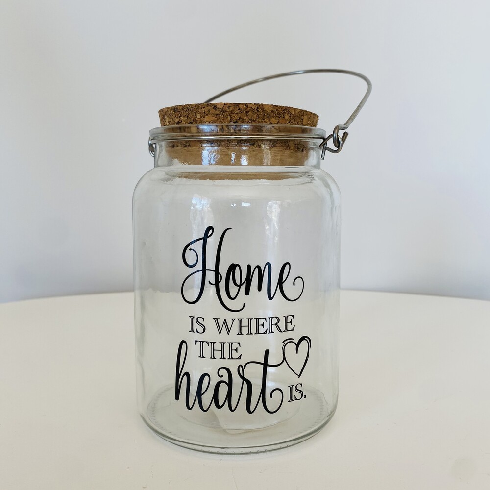 Pote de vidro transparente com tampa de cortiça e texto preto