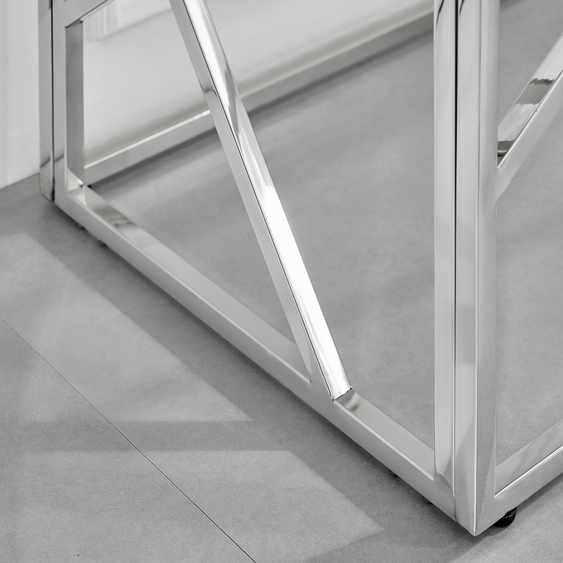 Estrutura metálica cromada quadrada sobre pavimento cinzento mate