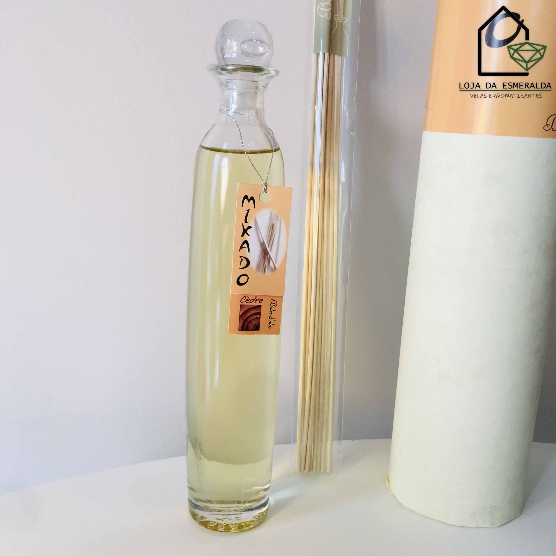 Frasco de difusor de aroma com etiqueta 'MIKADO' com palitos e embalagem cilíndrica ao lado