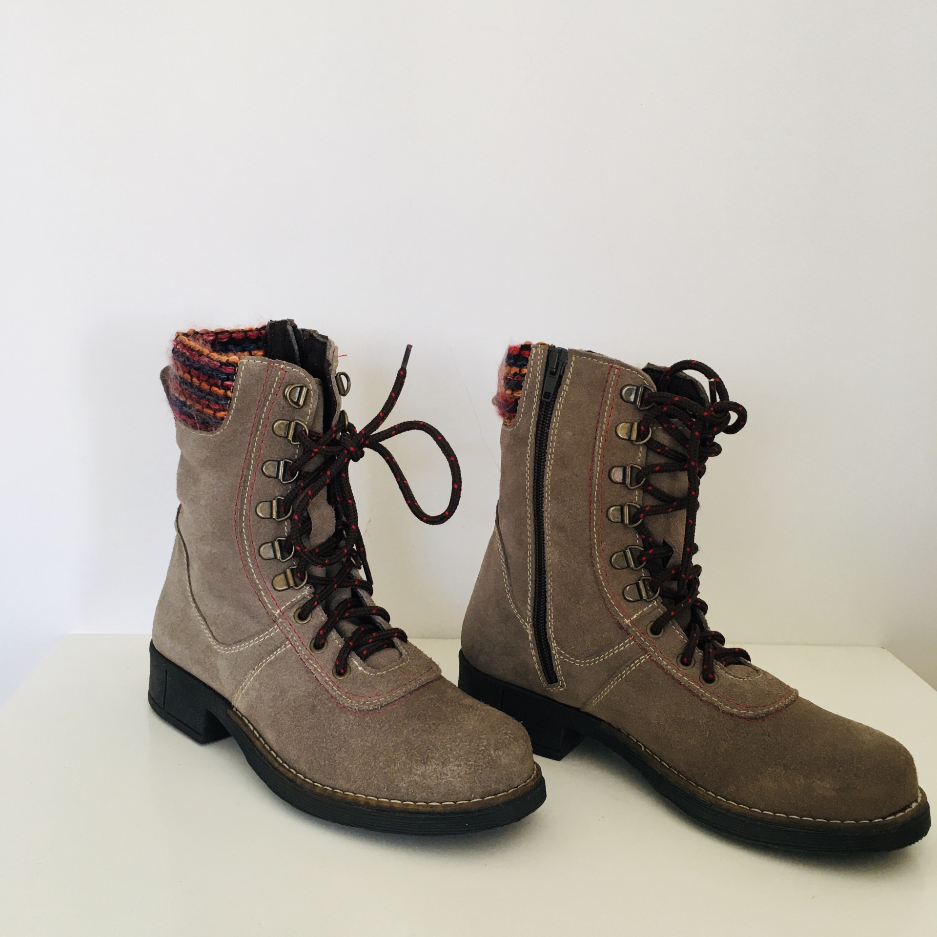 Botas militares em camurça bege com atacadores e detalhe de tecido multicolorido.