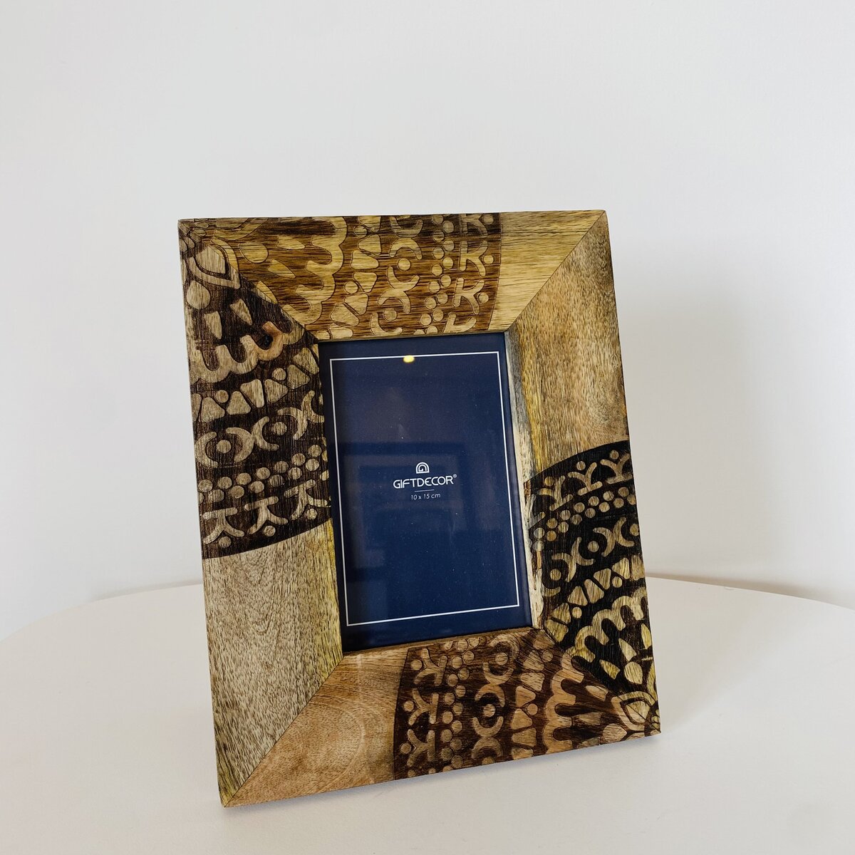 Moldura de madeira decorativa com padrões castanhos e inserção azul com texto