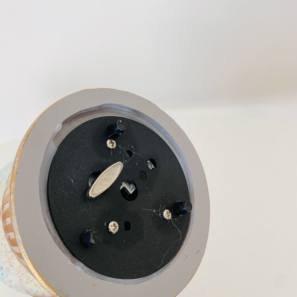 Base circular preta com pinos metálicos vista de baixo