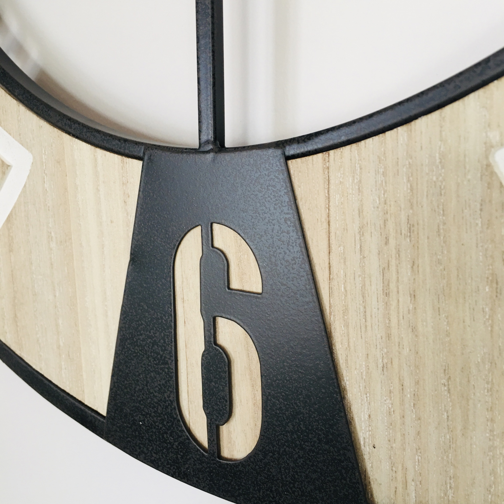 Relógio de parede com parte em madeira clara e número 6 em metal preto