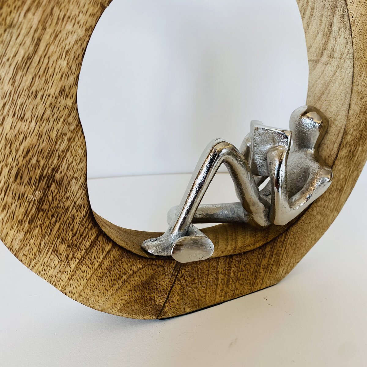 Espelho com moldura de madeira e escultura metálica de figura humana