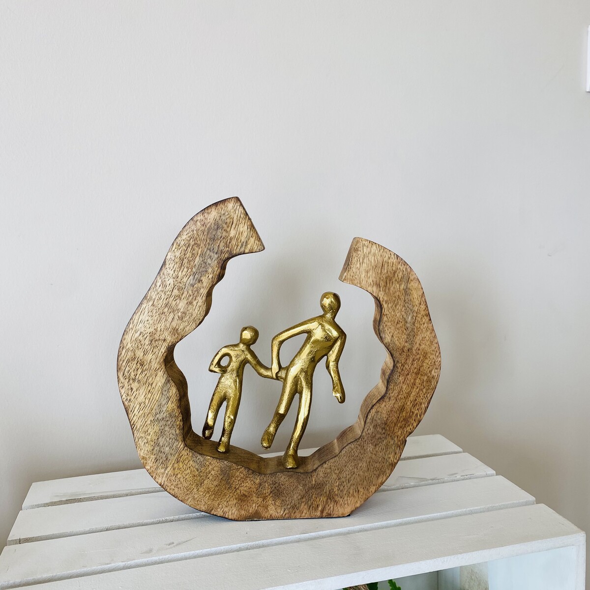 Escultura decorativa de figuras douradas em base de madeira rústica