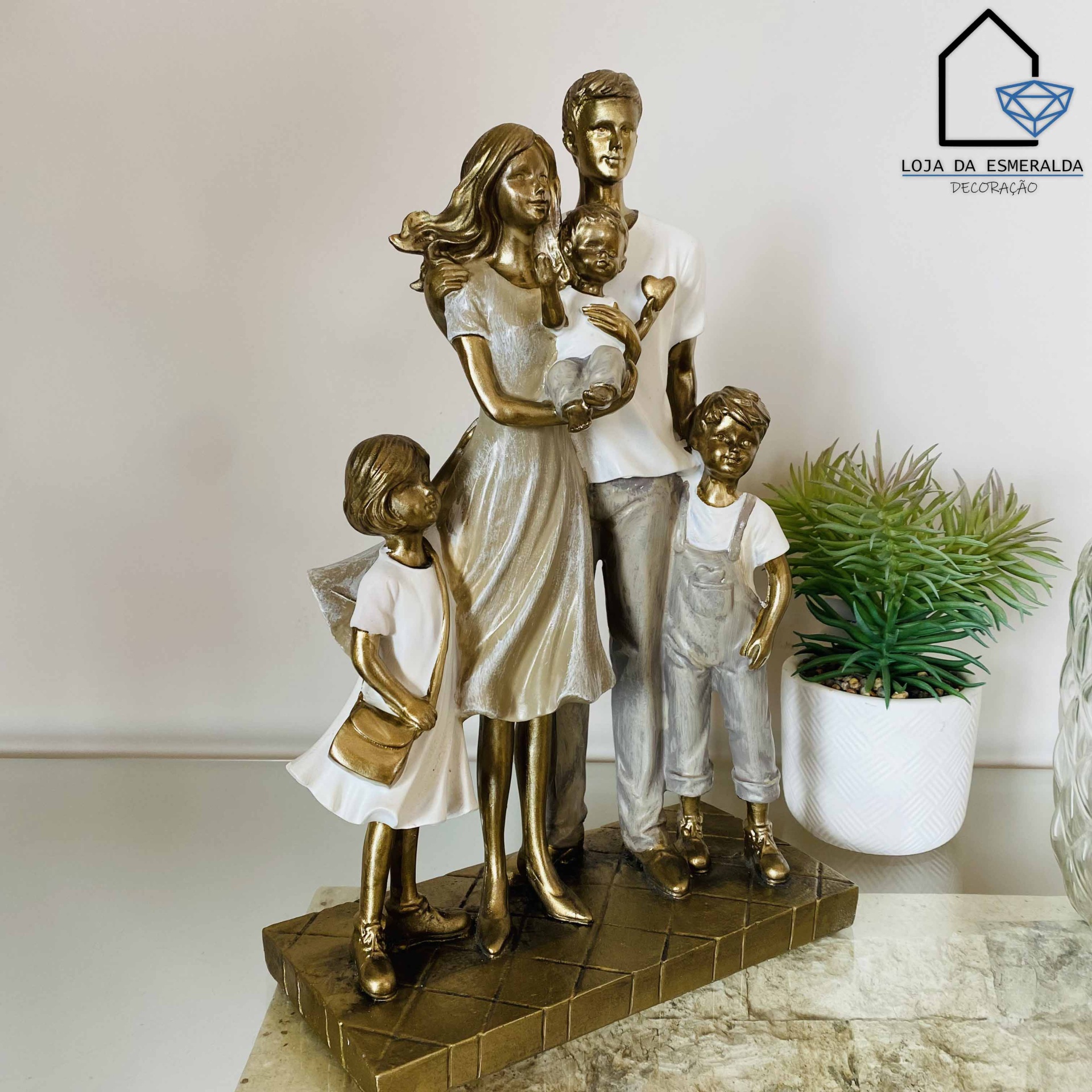 Escultura decorativa de família com cinco figuras douradas e brancas sobre base retangular